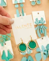 Aros colgantes con aro de acero dorado y dije circular de acrílico verde esmeralda con borde de strass.