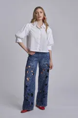 Camisa blanca de mangas 3/4 abullonadas con puños elásticos y cuello clásico.