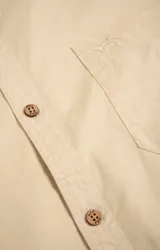 Camisa amarilla de algodón orgánico, manga larga con botones de madera, cuello italiano, calce regular, bolsillo de pecho con logo bordado.