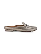 Mocasín mule destalonado color dorado, con detalle metálico ornamental.