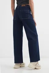 Pantalón jean azul oscuro de corte wide leg, con tiro alto y costuras a la vista.