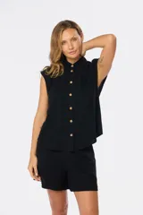 Camisa color beige de lino con botones de madera, cuello clásico y mangas cortas.