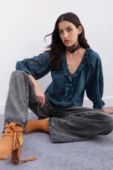 Camisa azul con detalles de plumetí, puntillas, alforzas y bordados. Mangas al codo abullonadas y cuello en V con volados.