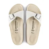 Sandalia tipo slide de una sola tira ancha, color blanco, con hebilla metálica ajustable. Presenta plantilla anatómica de corcho y látex.