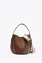 Bolso marrón formato saca con asa de mano y tira bandolera extraíble. Incluye cartera con bolsillo extraíble y cierre mediante botón imantado.