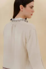 Saco tejido color negro con detalle en escote y puños a dos tonos, corte acampanado y detalle en la espalda con cambio de punto y color.