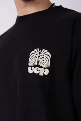 Remera negra de corte oversize con estampado blanco en el pecho.