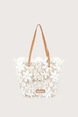 Bolso tipo shopper de encaje blanco con diseño floral, forro color beige y asas de cuero color camel.