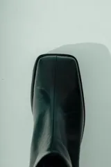 Bota corta de cuero color bordó con acabado natural, caña ajustada y punta suavemente afinada. Posee un taco ancho y estable de aproximadamente 5 cm.