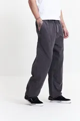 Pantalón gris oscuro de corte amplio, estilo carpenter, con bolsillos laterales y traseros.