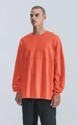 Remera de manga larga color naranja con cuello redondo.