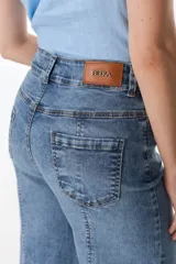 Pantalón de jean celeste con corte acampanado, tiro alto y costuras verticales al frente.