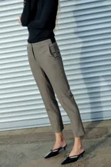 Pantalón tobillero gris con textura, de tiro medio y corte recto. Tiene cintura elástica en la parte trasera, bolsillos delanteros y falsos bolsillos traseros.