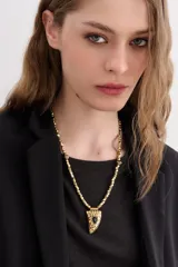 Collar regulable con cadena de eslabones facetados color plateado y dije metálico con forma de cuerno con piedra incrustada.