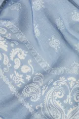 Pañuelo cuadrado celeste con estampado de cachemir en blanco y terminación desflecada.