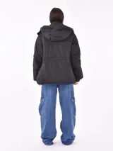 Campera puffer roja con capucha, cierre frontal con cremallera y bolsillos laterales.