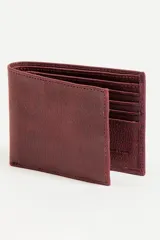Billetera de cuero color tinto con múltiples compartimentos para tarjetas y billetes.