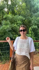 Blusa blanca con cuerpo de encaje de crochet cuadrillé y mangas abuchonadas de lino.