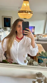 Collar corto de cuentas rojas de diferentes tamaños y formas, con cierre ajustable.