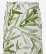 Pollera midi evasé de mujer, con cintura elástica y estampado de follaje en tonos verdes sobre fondo blanco.