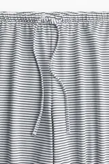 Pantalón de corte holgado en punto suave con rayas horizontales. Modelo con piernas rectas y elástico revestido con cordón para ajustar en la cintura.