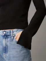 Top negro de algodón regenerativo con textura de canalé, corte slim, cuello redondo, mangas largas con puños con abertura e insignia con el monograma de Calvin Klein en el bajo.