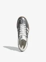 Zapatillas Adidas Samba OG W plateadas metalizadas con efecto craquelado, las tres tiras laterales blancas y suela de goma color caramelo.