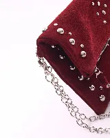 Bandolera de cuero color bordó con tachas plateadas y correa de cadena metálica desmontable.