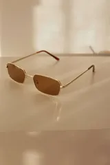 Lentes de sol rectangulares con armazón metálico dorado y lentes marrones con protección UV400.
