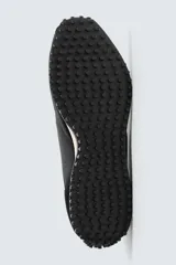 Zapatilla de cordones negra de estilo retro. Parte superior fabricada en tejido técnico y detalles en piel con acabado serraje. Suela dentada con detalle a contraste.