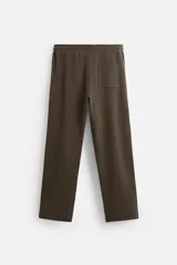 Pantalón negro de corte recto confeccionado en tejido interlock de algodón con elasticidad. Tiene cintura elástica ajustable con cordón, bolsillos frontales y bolsillos traseros de vivo.