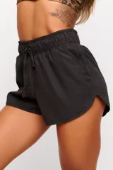 Short deportivo negro de tejido suave con elástico en la cintura y cordón ajustable.