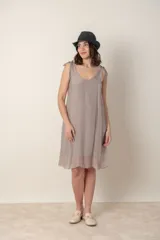 Vestido corto negro de seda con breteles finos anudados en los hombros y escote en V.