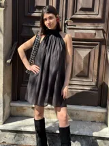 Vestido corto negro con cuello halter y corte holgado.