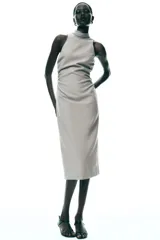 Vestido midi color gris topo, de cuello halter con lazada combinada a tono. Bajo con abertura en espalda. Cierre en espalda con cremallera, abertura y botón.