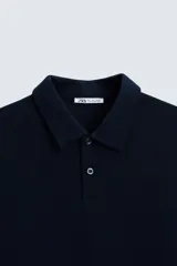 Polo de piqué color crudo, corte regular fit, cuello solapa con cierre de botonadura y mangas cortas.