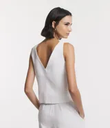 Blusa blanca sin mangas de liocel, con escote en V delantero y trasero, y breteles anchos.