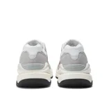 Championes New Balance modelo W5740SLC, con capellada de malla y gamuza en tonos gris claro, blanco y rosado. Presenta una entresuela sobredimensionada de color crema y suela exterior negra.