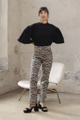 Pantalón de jean de corte recto con estampado de cebra en tonos beige y negro.