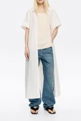 Vestido largo blanco de algodón, corte oversize, con cuello camisero, manga corta recta y cierre frontal con botones.