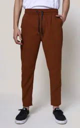Pantalón de jogging color marrón chocolate, de corte recto y calce regular, con cintura elástica ajustable con cordón, bolsillos laterales y puños con cierre.