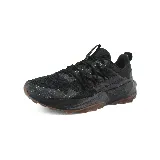 Championes negros de trail running New Balance, con suela marrón y detalles en gris.
