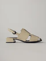 Sandalias de cuero color beige con diseño entretejido, taco bajo y tira trasera con hebilla.