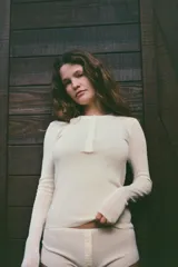 Camiseta negra de manga larga con cuello redondo y cierre frontal con botones.