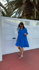 Vestido corto azul eléctrico de lino, con escote en V, mangas cortas con volados y corte escalonado en la falda.