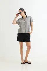 Camisa gris sin mangas de lino con cuello clásico y cierre frontal con botones.