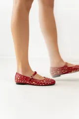 Chatas negras de cuero con correa sobre el empeine y hebilla plateada. Decoradas con tachas plateadas y doradas de diferentes tamaños.