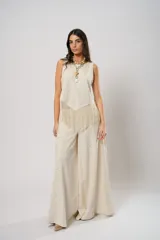 Pantalón palazzo color beige con bordados calados en forma de paisley en los laterales.