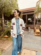 Cardigan tejido artesanalmente en lana color crudo, con diseño de copo de nieve en la espalda y bordados a mano.