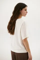 Blusa color crudo de lino con cuello redondo y mangas cortas.